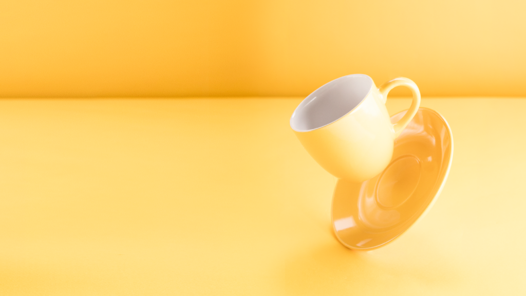 Imagem de xícara de café vazia sobre fundo amarelo